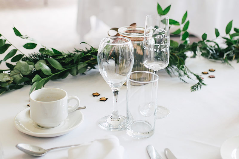 table dressée avec tasse à café, verre de vin et champagne, décoration avec des feuilles