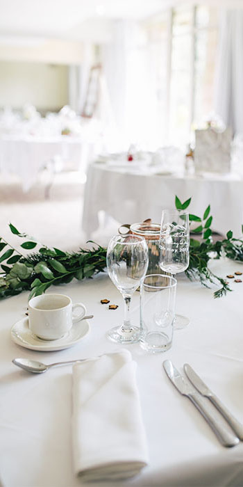 table dressée avec tasse à café, verre de vin et champagne, décoration avec des feuilles